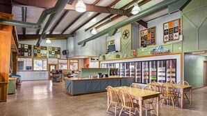 A spacious restaurant with a central island, wooden tables and chairs, and a variety of memorabilia on the walls.