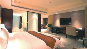 A hotel room with a large bed, a desk with a computer, a TV, and a seating area. - Yohol hotel Xi'an (Xi'an)
