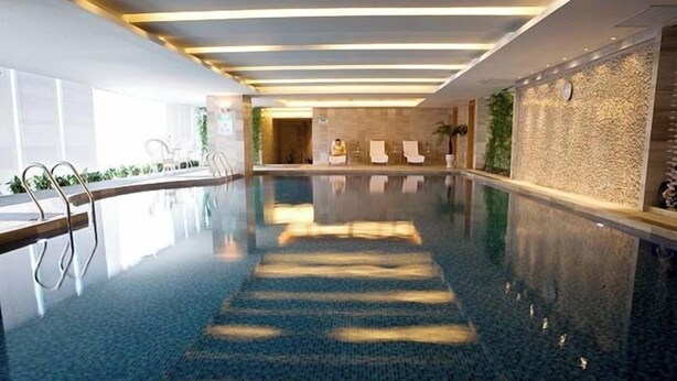 A modern indoor swimming pool with clear water, a central lane, and a reception area in the background. - Yohol hotel Xi'an (Xi'an)