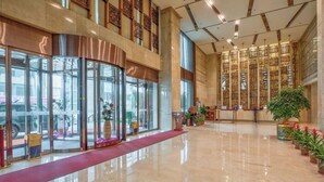 A spacious lobby with a red carpet, large glass doors, and a decorative wall with vertical patterns. - Yohol hotel Xi'an (Xi'an)