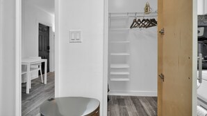 Habitació moderna i minimalista amb una porta de fusta, una paret blanca i un terra de color gris.