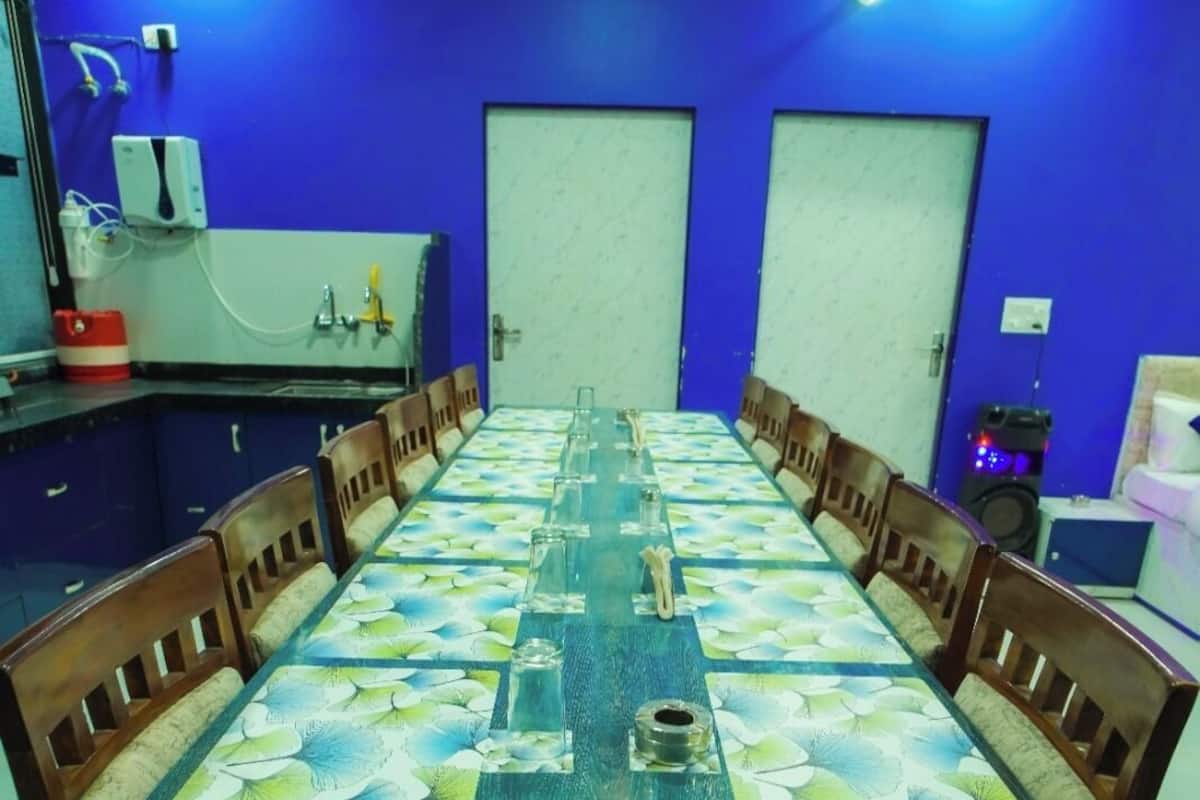 A conference room with a long table, wooden chairs, and blue walls.