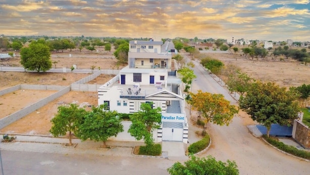 A two-story building named Paradise Point with a flat roof, a covered outdoor seating area, and a gated entrance. - Paradise Point Resort (Jaipur)