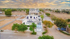 A two-story building named Paradise Point with a flat roof, a covered outdoor seating area, and a gated entrance. - Paradise Point Resort (Jaipur)