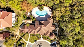 Vista aérea de un resort con piscina, área de estacionamiento y jardín ajardinado.