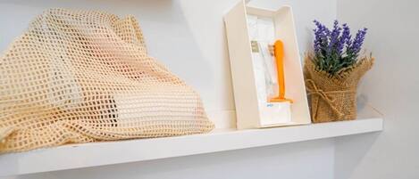 A white shelf with a woven bag, a framed item, and a small basket with lavender.