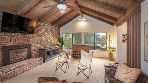 A spacious living area with a brick fireplace, leather sofas, and a ceiling fan. - Beautiful 4-bedroom close to Sequoia Nat’l Park w/ WiFi, Pool, Spa, Pet Friendly (Three Rivers)