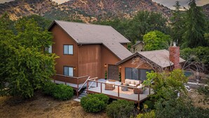 A modern two-story house with a wooden exterior, a deck, and a view of a mountainous landscape. - Beautiful 4-bedroom close to Sequoia Nat’l Park w/ WiFi, Pool, Spa, Pet Friendly (Three Rivers)