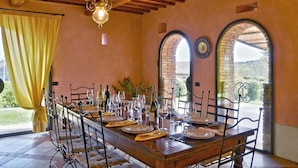 A dining area with a long wooden table set for a meal, featuring wine glasses, plates, and cutlery. - Villa Scuderie -  Guardistallo, Pisa (Guardistallo)