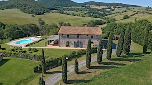 A stone villa with a swimming pool, surrounded by rolling hills and cypress trees. - Villa Scuderie -  Guardistallo, Pisa (Guardistallo)