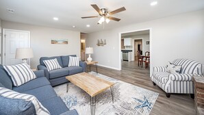 A modern living room with a sectional sofa, a coffee table, and striped armchairs. - Stay @ Rapp on the Rappahannock River, Welcome & Relax! (Dunnsville)
