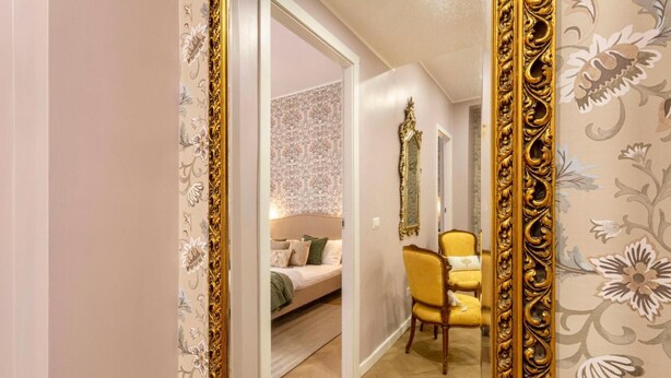 A bedroom with a bed, a chair, and a mirror. - Amelie   Jewel of Trastevere (ROMA)