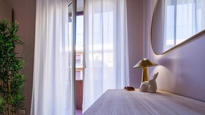 A hotel room with a bed, a lamp, a mirror, and a potted plant. - Amelie   Jewel of Trastevere (ROMA)