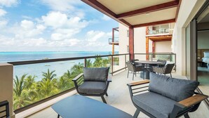 A balcony with a view of the ocean, furnished with two chairs and a table. - Artila Isla Mujeres: Exclusive Oceanview Stay with Pool & Beach Access (Isla Mujeres)