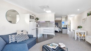 Eine moderne Wohnung mit Wohnzimmer, Küchenzeile und Schlafzimmer.