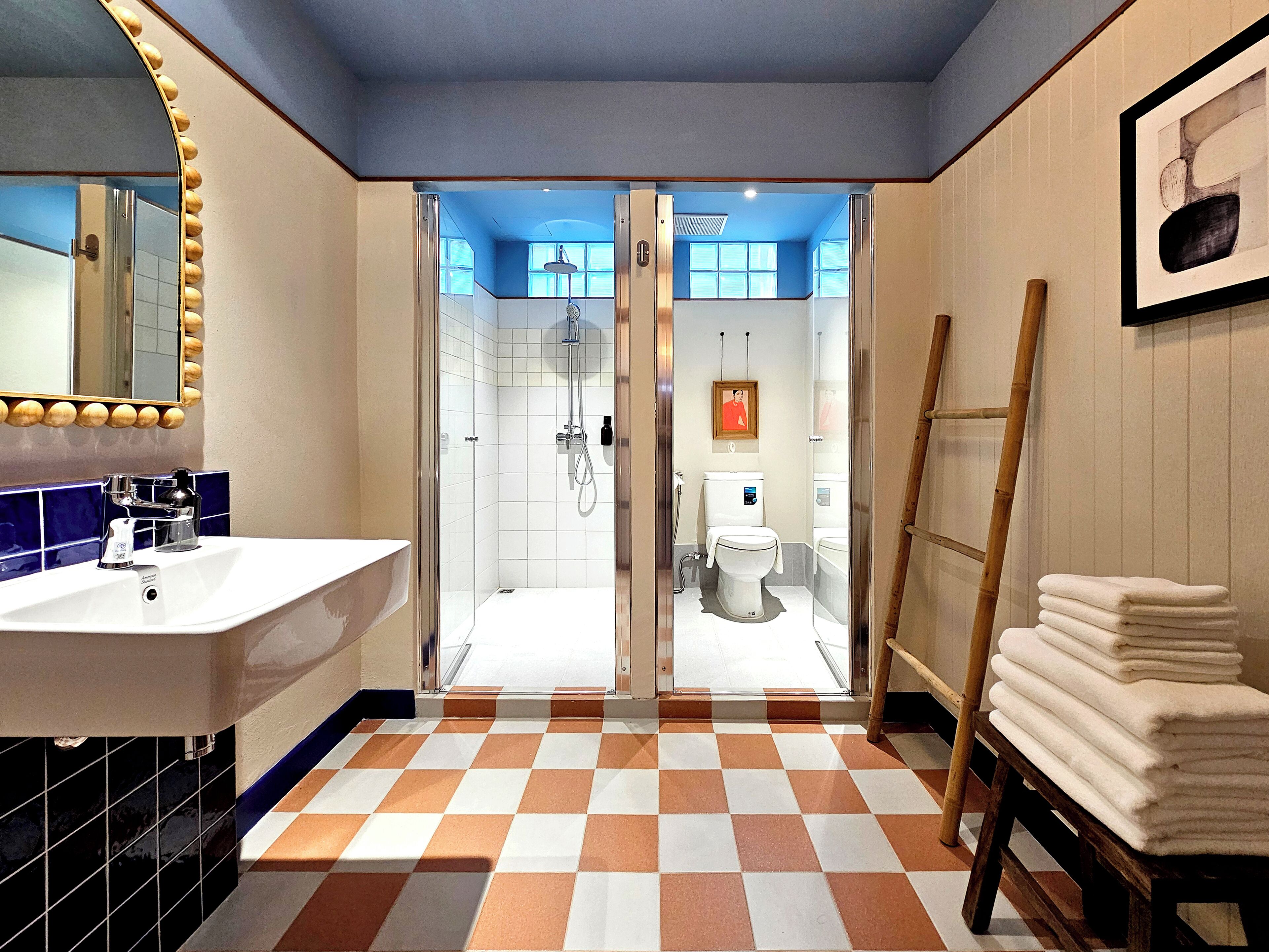 Une salle de bain avec un carrelage à motifs, un lavabo, une douche et des toilettes.