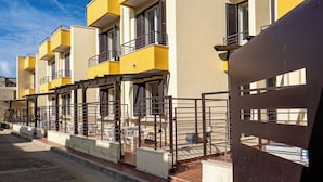 A row of yellow buildings with balconies and a gated entrance. - Villino Sole 4 Airco Near Beach & Centre (Porto Cesareo)