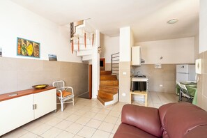 A compact living space with a kitchen, dining area, and a staircase. - Villino Sole 4 Airco Near Beach & Centre (Porto Cesareo)
