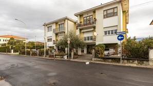 Une rue résidentielle bordée de maisons à deux étages, avec un panneau indiquant la limite de vitesse et un panneau de signalisation.