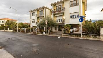 Una calle residencial con casas de dos pisos, una señal de límite de velocidad y una señal de dirección.