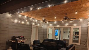 A room with a ceiling fan, string lights, a grill, and a television. - Blue Resort of Yosemite-Pool, Hot Tub, Theatre and Games (Mariposa)