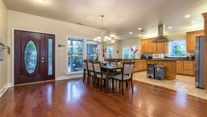 A spacious kitchen with wooden cabinets, a dining table with chairs, and a large window. - Blue Resort of Yosemite-Pool, Hot Tub, Theatre and Games (Mariposa)