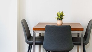 A small dining table with a potted plant, two chairs, and a white wall. - MetaWise 1Bed Next to ICC Darling Harbour  58 (Sydney)