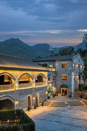 A traditional building with a courtyard, arched walkways, and a mountain backdrop. - CHONGQING MANQUE MANSION (Chongqing)