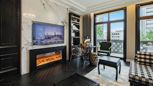 A modern living room with a fireplace, a television, and a view of the city through large windows. - CHONGQING MANQUE MANSION (Chongqing)