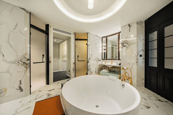 A modern bathroom with a large freestanding bathtub, marble walls, and a black door. - CHONGQING MANQUE MANSION (Chongqing)