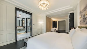 A modern hotel room with a large bed, a bedside table, a floor lamp, and a painting on the wall. - CHONGQING MANQUE MANSION (Chongqing)