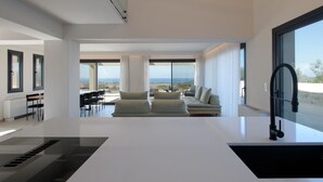 Un salon moderne doté d’une grande fenêtre, d’un canapé et d’un coin repas avec des chaises et une table.
