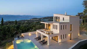 Une maison moderne à deux étages avec piscine, offrant une vue imprenable sur un paysage magnifique.