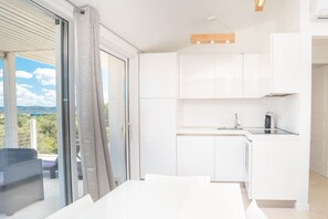 A modern kitchen with white cabinets and a dining area with a table.