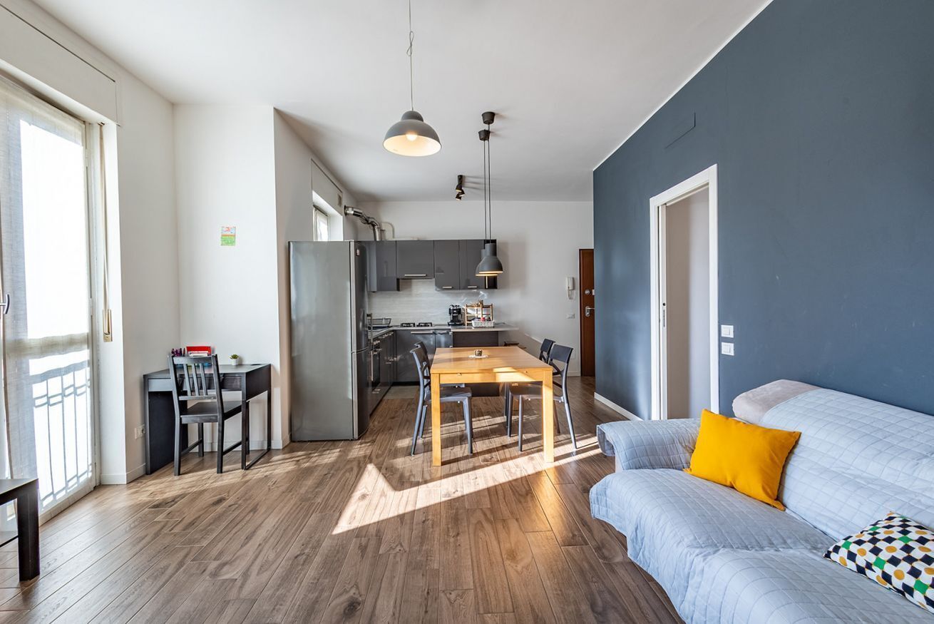 A modern apartment with a dining area, kitchen, and living room.