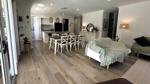 A modern interior with a dining area, kitchen, and living space. - The Mermaid's Retreat - Pool in Kiama! (Kiama)