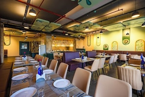 Un restaurante con varias mesas, cabinas y una zona de bar.