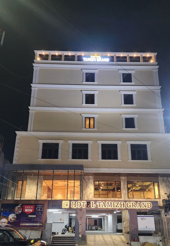 A multi-story hotel with a sign reading "HOTEL TAMIZH GRAND". - HOTEL TAMIZH GRAND (Puducherry)