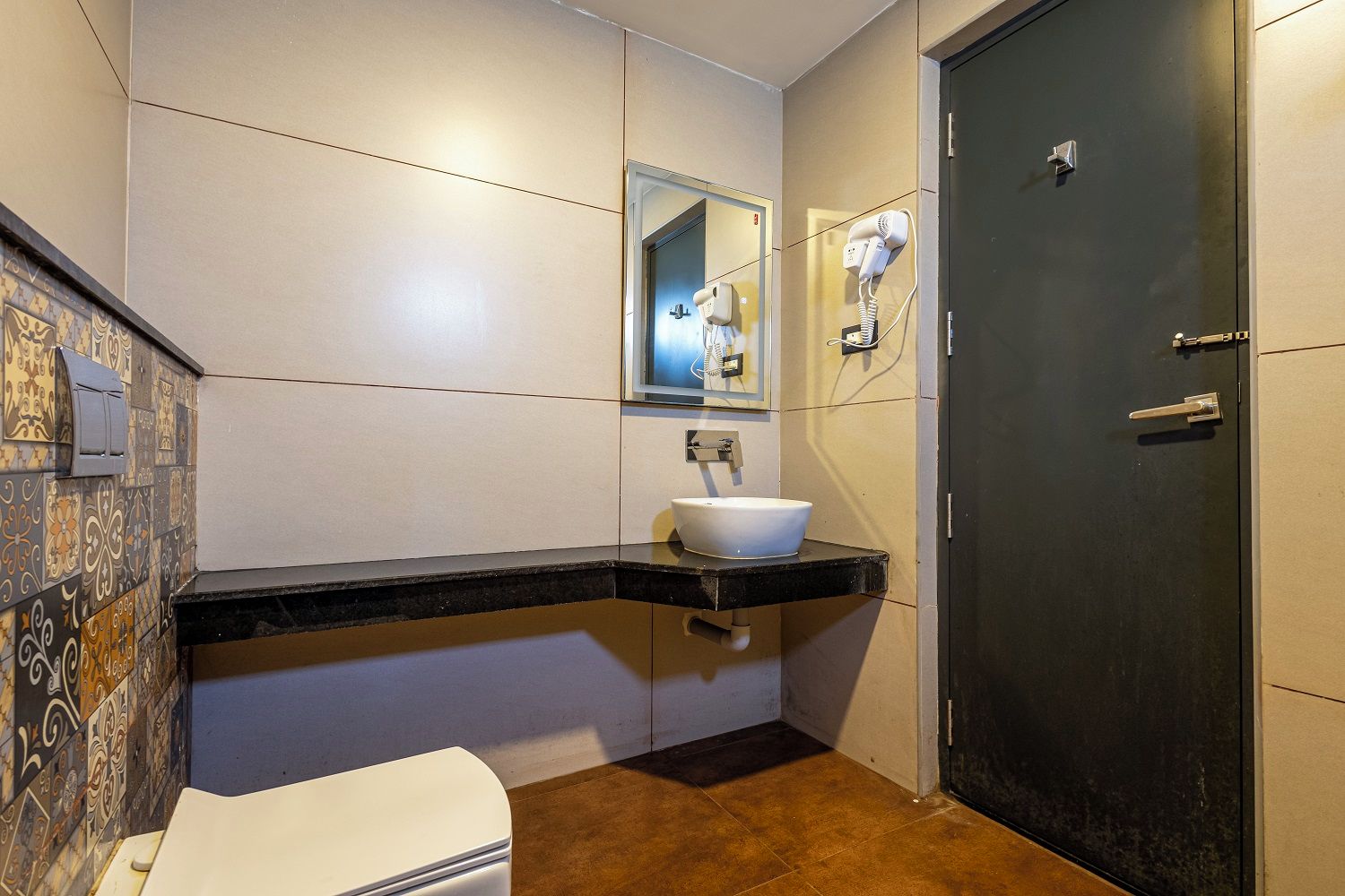 A bathroom with a white sink, a mirror, a hairdryer, and a toilet.