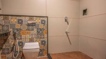 A bathroom with a toilet, shower, and tiled walls.