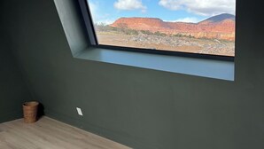 A room with a skylight, a bed, and a view of red rock formations. - #57 Star-Gazing A-frame cabin, 2 double beds, pet friendly bathroom at bathhouse (Teasdale)