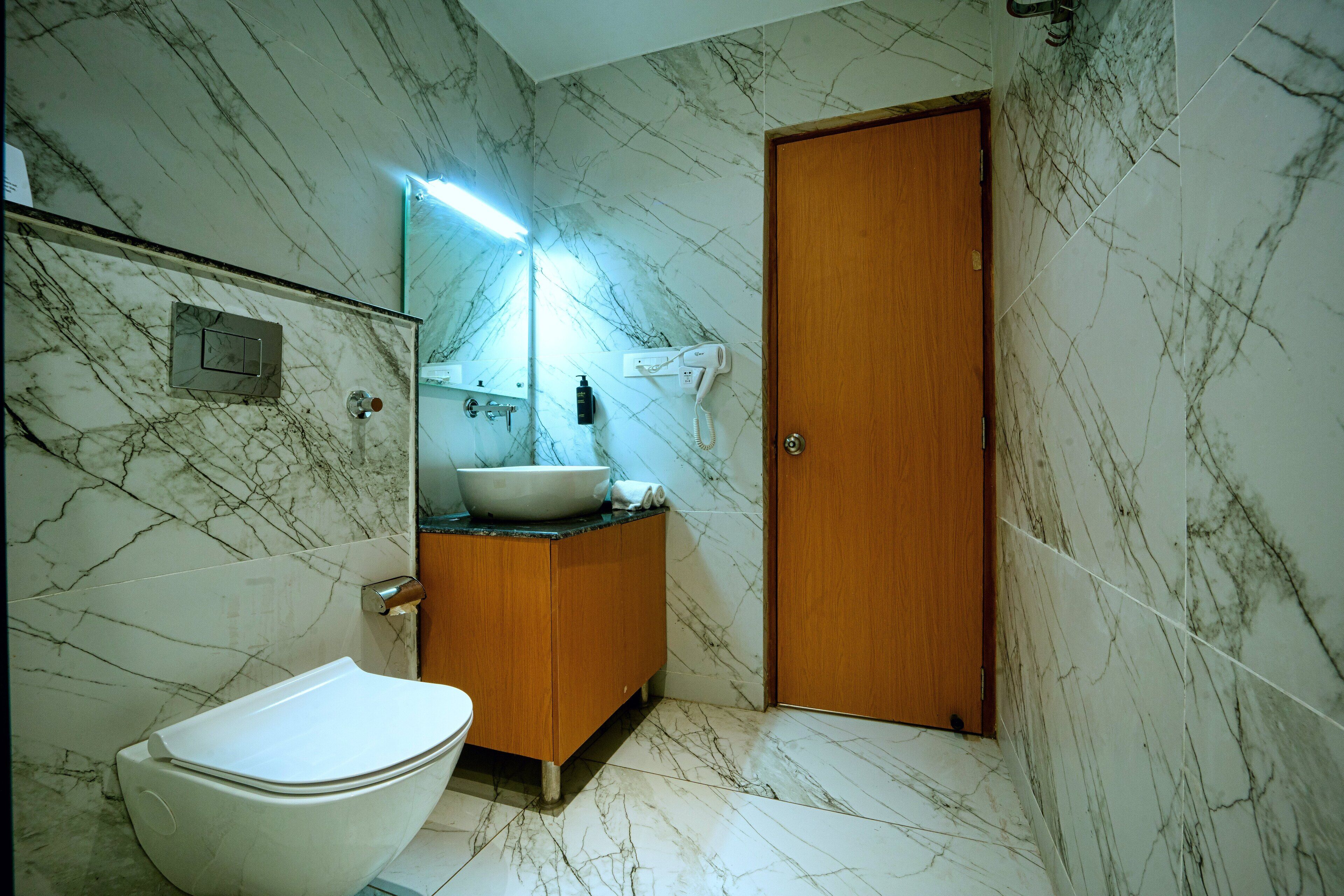 A bathroom with a toilet, sink, and wooden door.