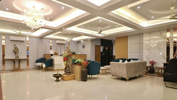 A spacious lobby with a high ceiling, modern furniture, and decorative elements like a chandelier and statues. - Grand Legacy Beacon Dehradun (Dehradun)