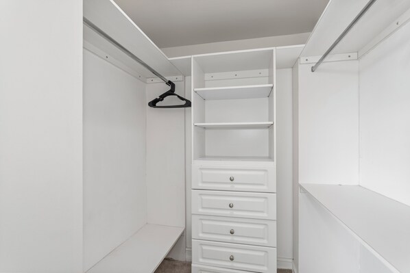 A white walk-in closet with open shelves and drawers. - Bay Harbor Sunset Apt 3C (Bay Harbor Islands)