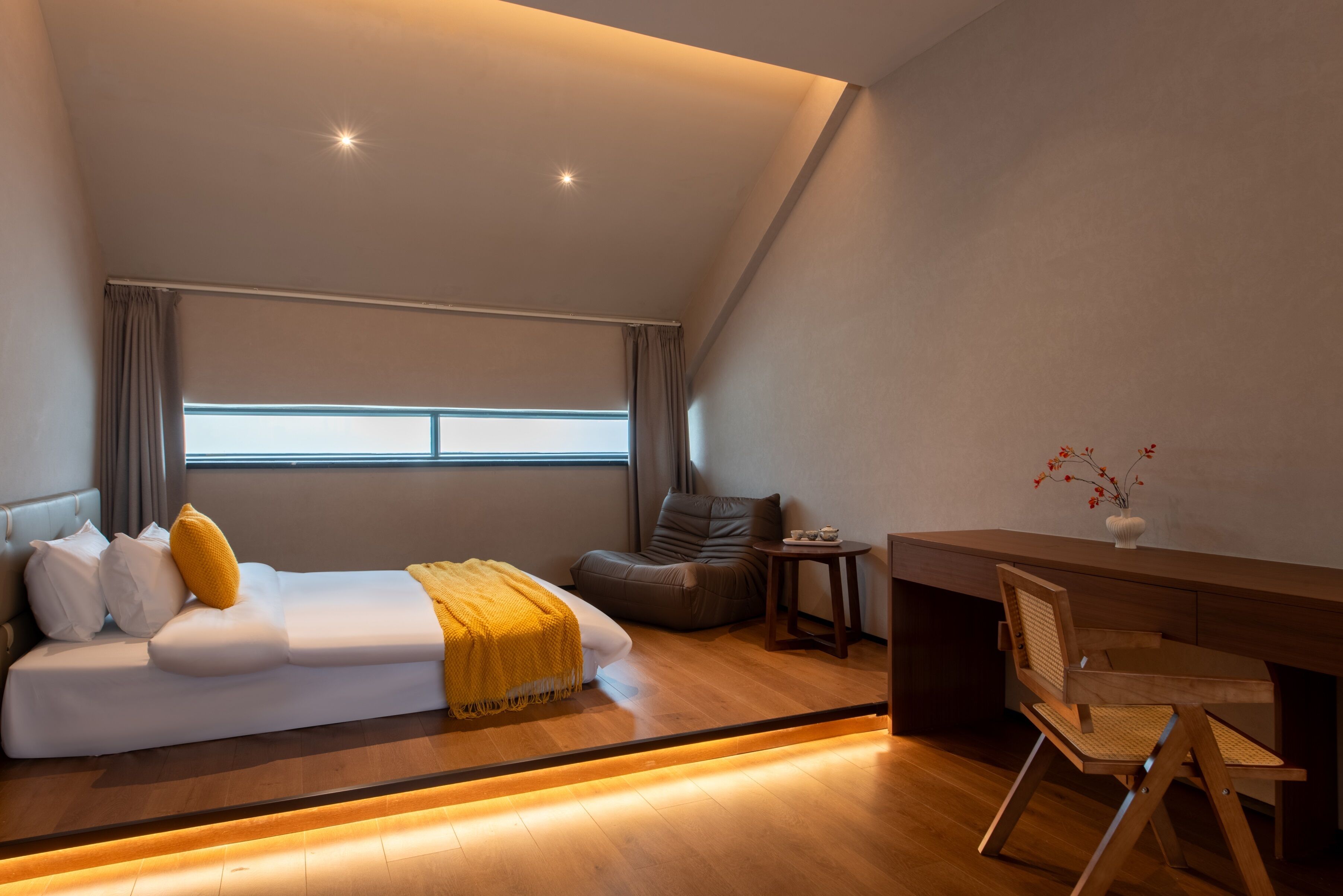 A modern bedroom with a bed, a desk, and a chair.