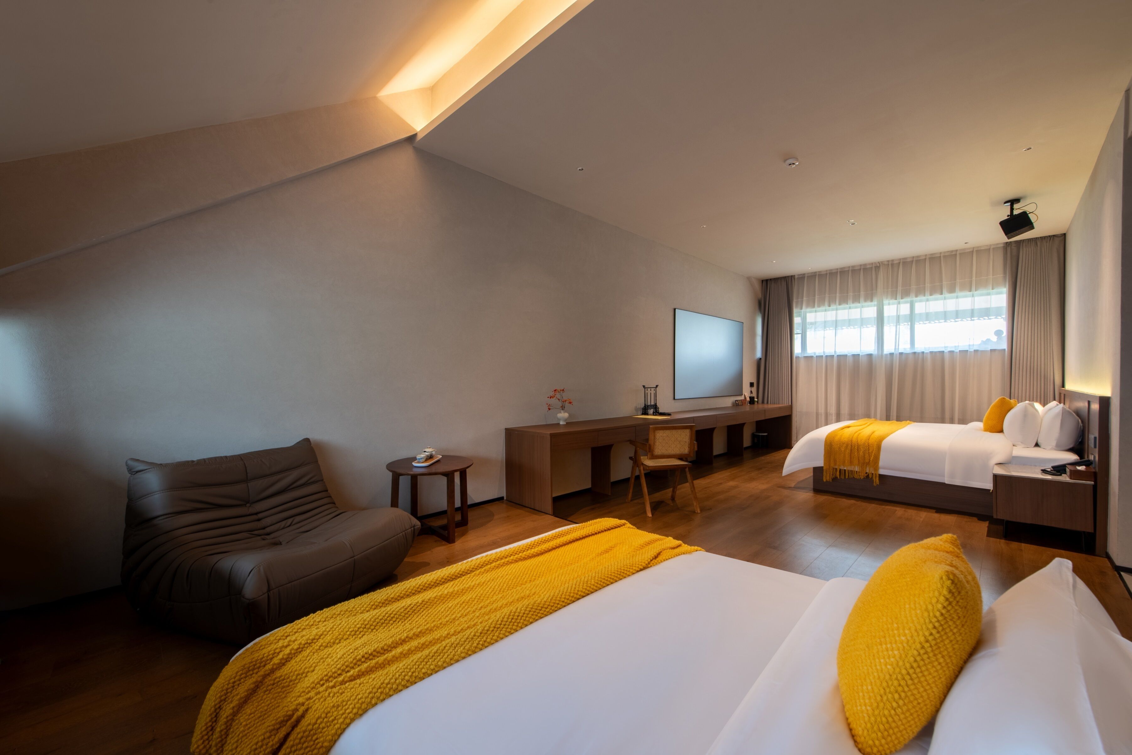 Een moderne hotelkamer met een groot bed, een bureau, een stoel en een televisie.