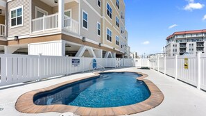 A residential building with a swimming pool, white fences, and balconies. - Residence 304S at The Sandcastle Condominiums (Wildwood Crest)