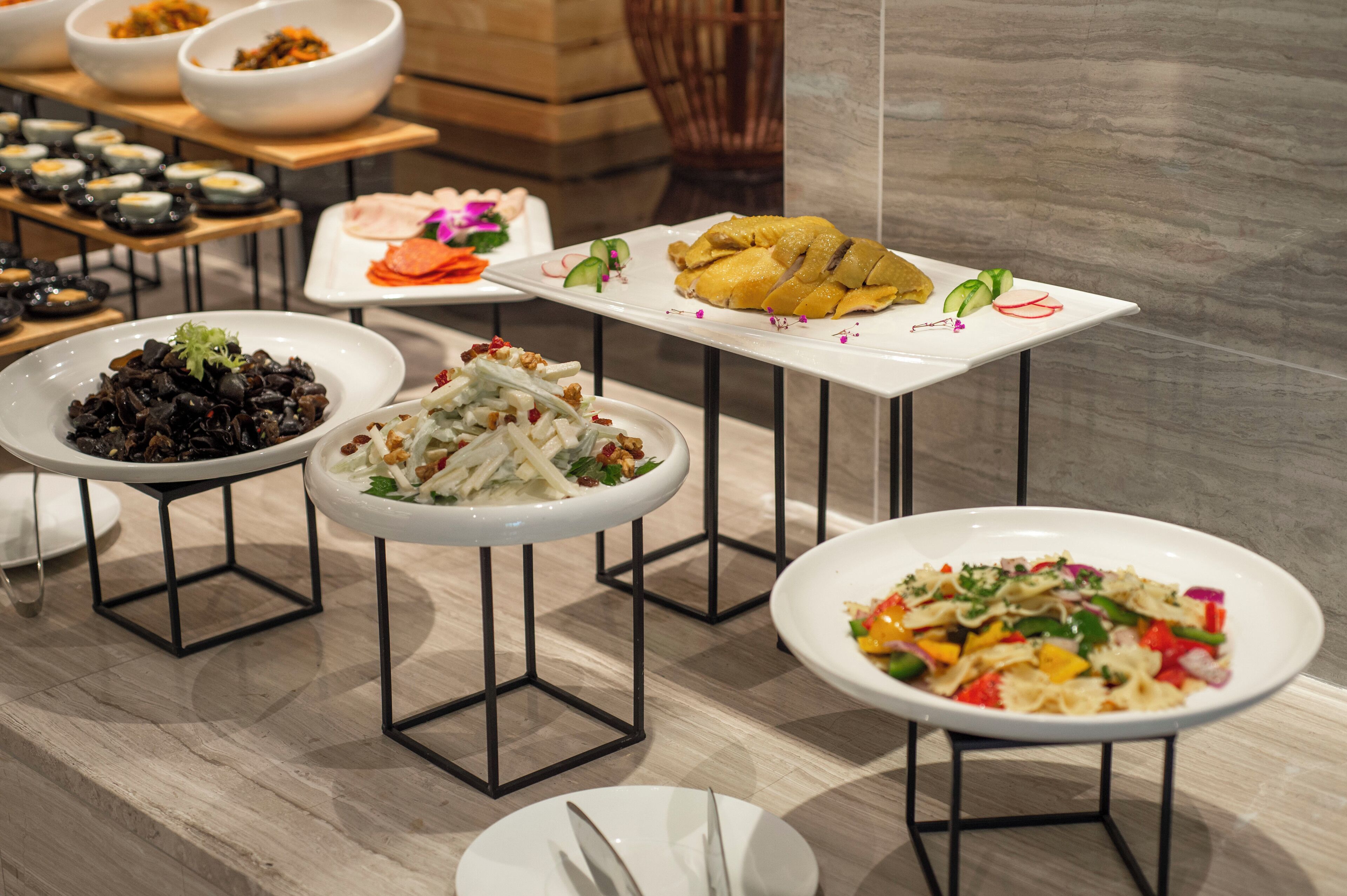 A variety of dishes on a buffet table with multiple serving stations.