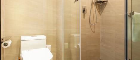 Un baño moderno con ducha envuelta en vidrio, inodoro y suelo de mármol.