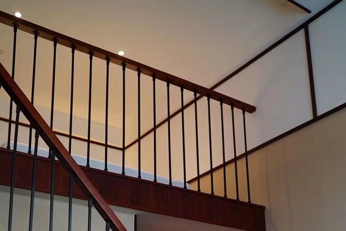 A modern interior with a wooden staircase, a mirror, and a light switch on the wall.